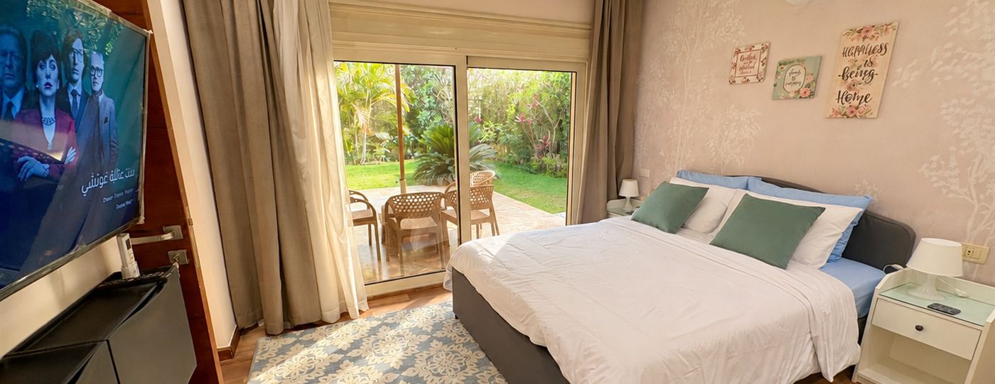 Bedroom with a wide bed and sliding doors opening onto the private garden