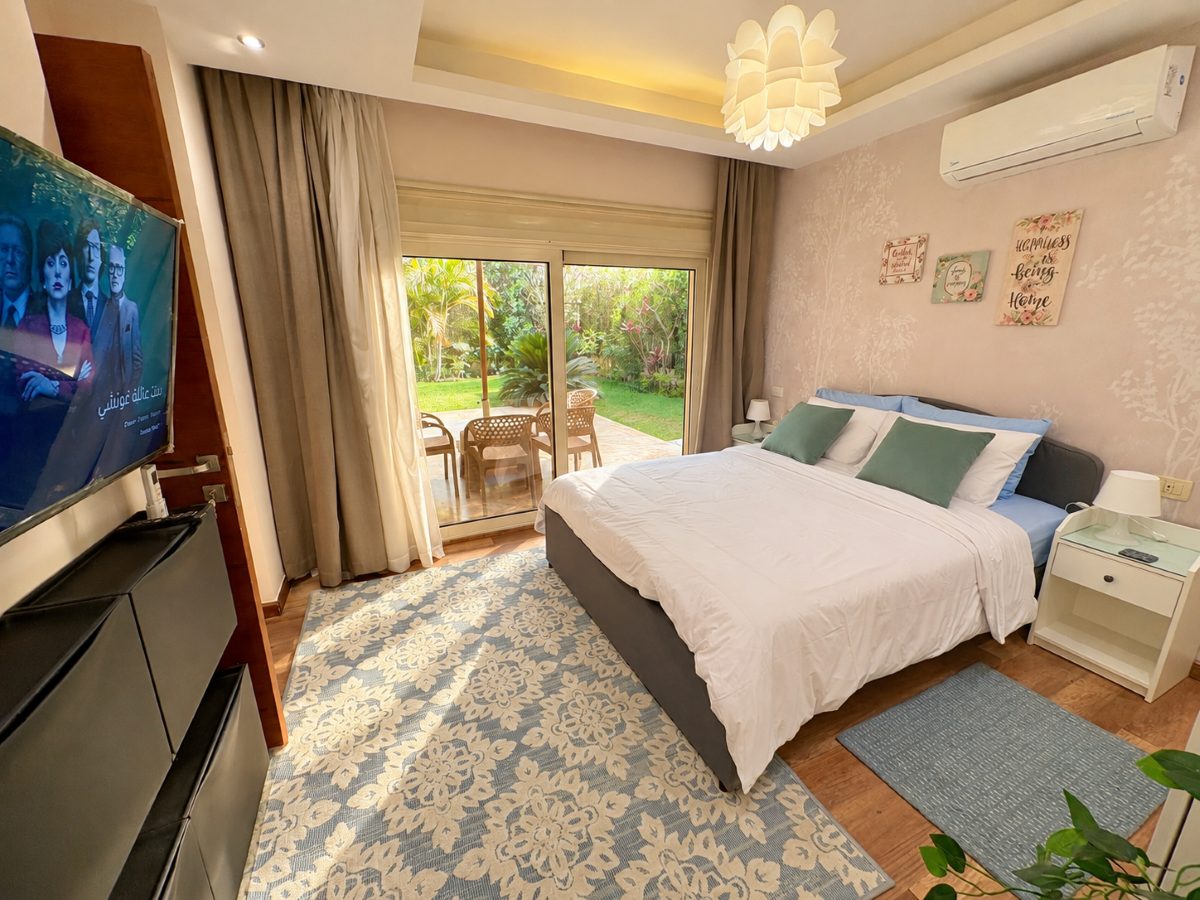 Bedroom with a wide bed and sliding doors opening onto the garden