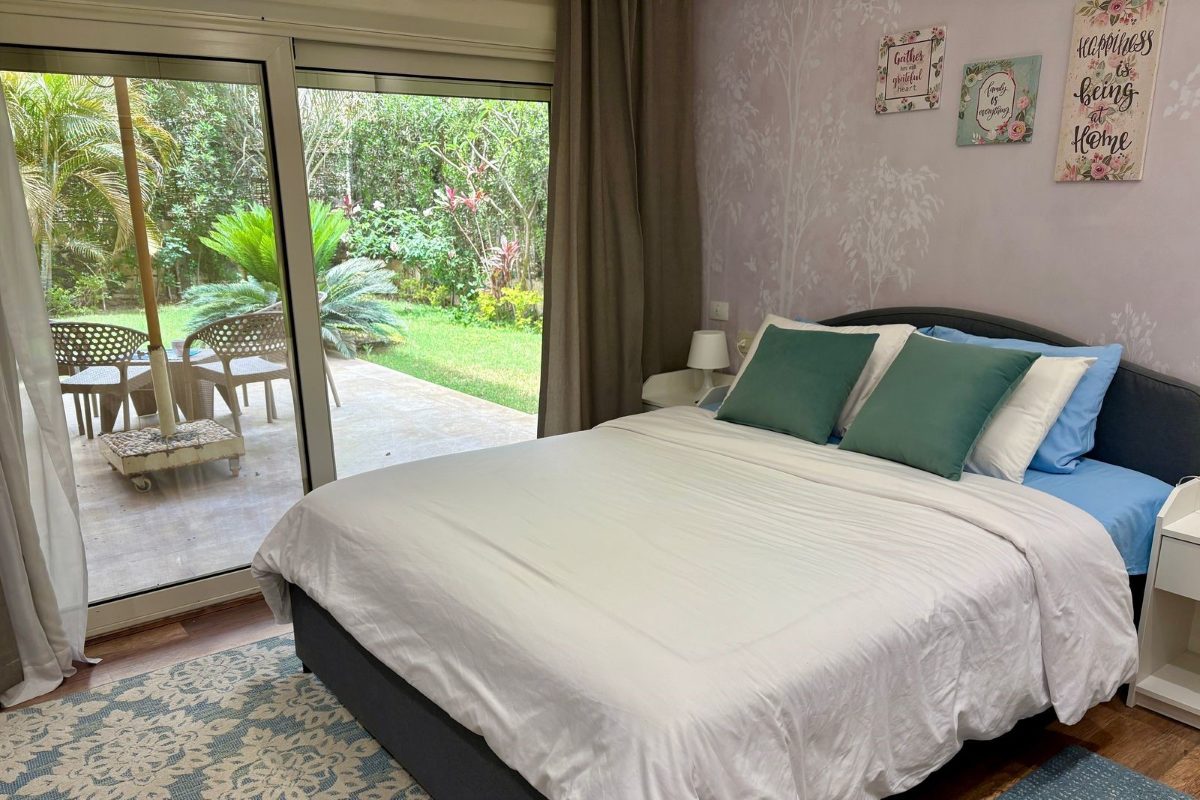 The bed seen from inside, looking out through the doors to the planted garden