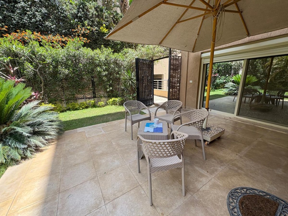 Garden seating with chairs and a table under a large parasol