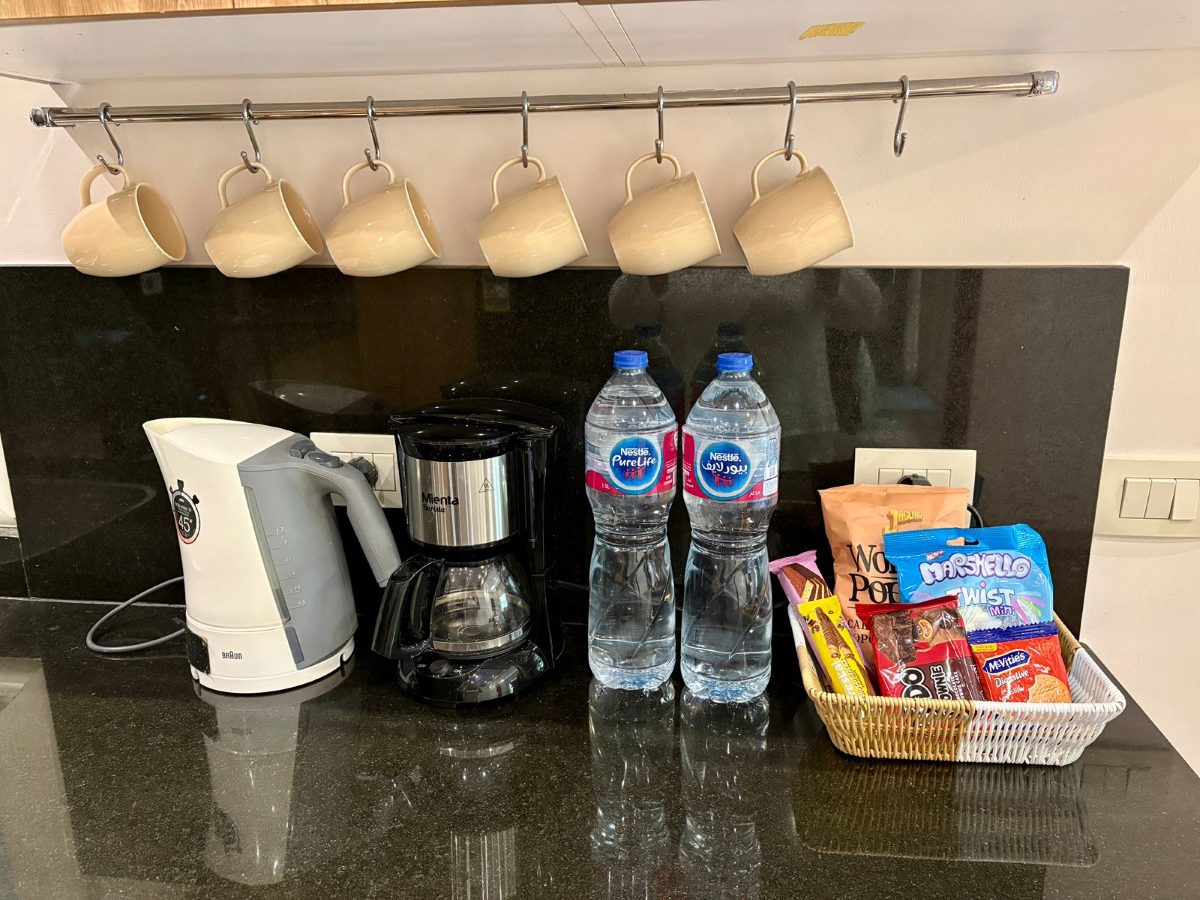 Filter coffee machine, kettle, two bottles of water and a snack basket on the counter