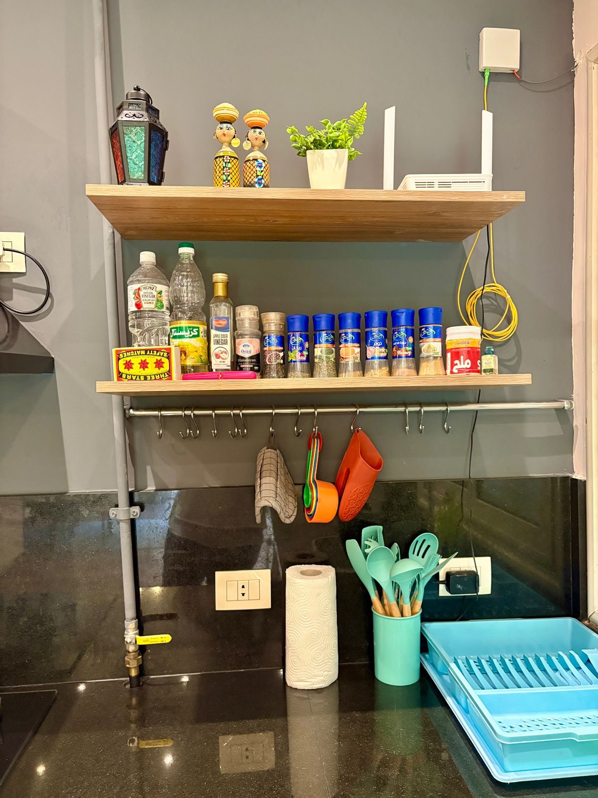 Shelf of seasonings and a rail of cooking utensils in the kitchen