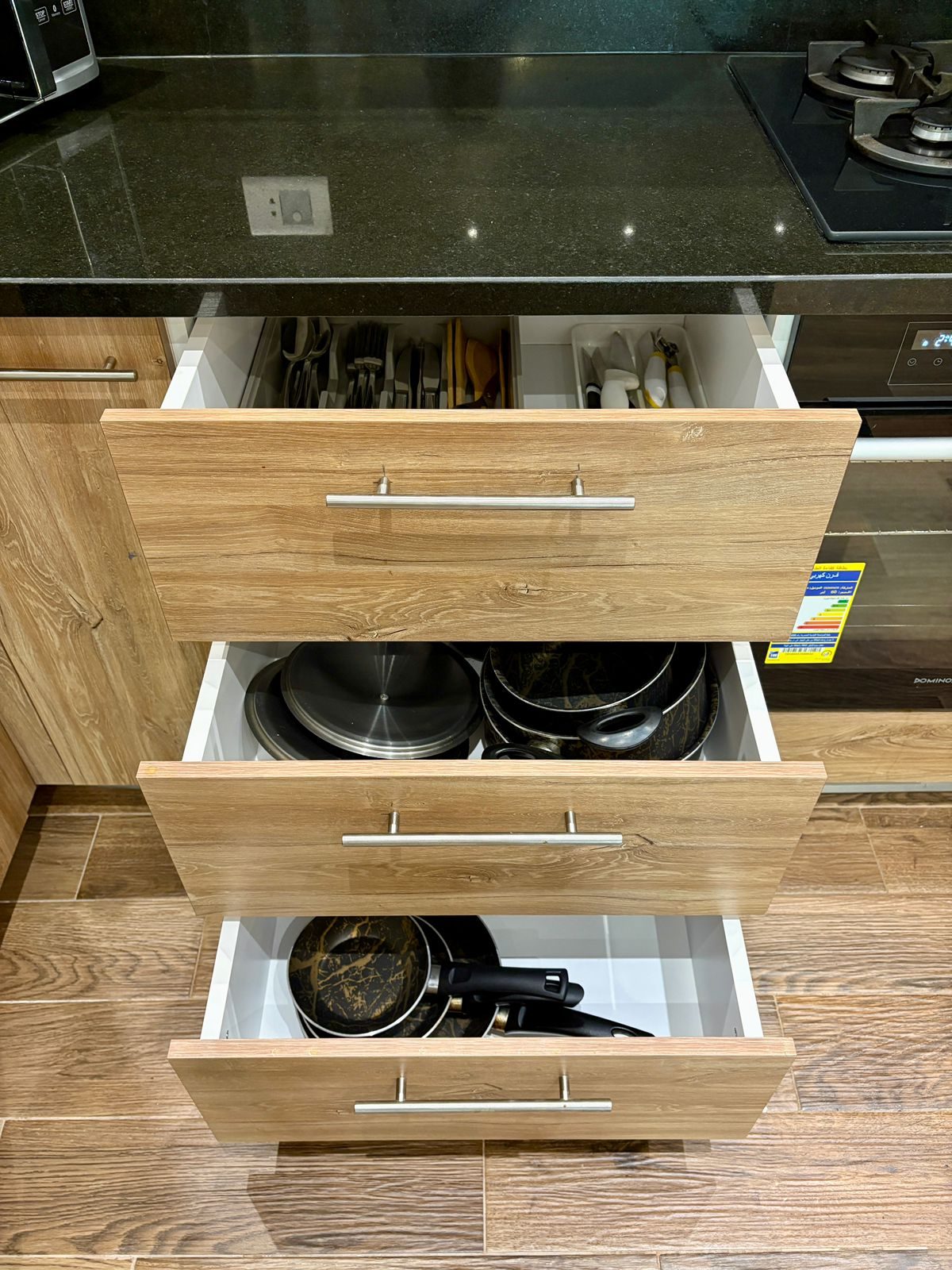 Open drawers showing pots, pans and kitchen utensils
