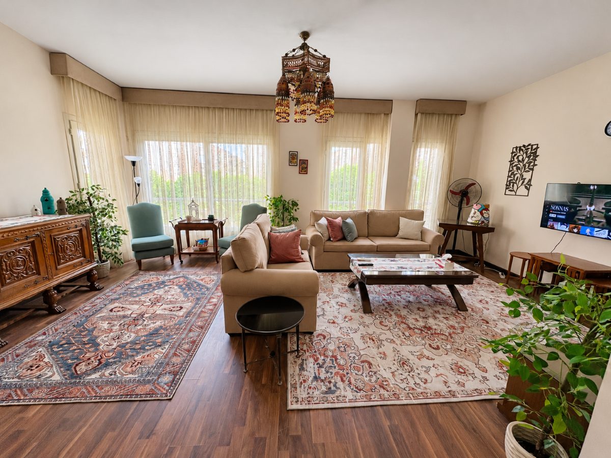 Bright vintage living room with generous seating, oriental rugs and large windows