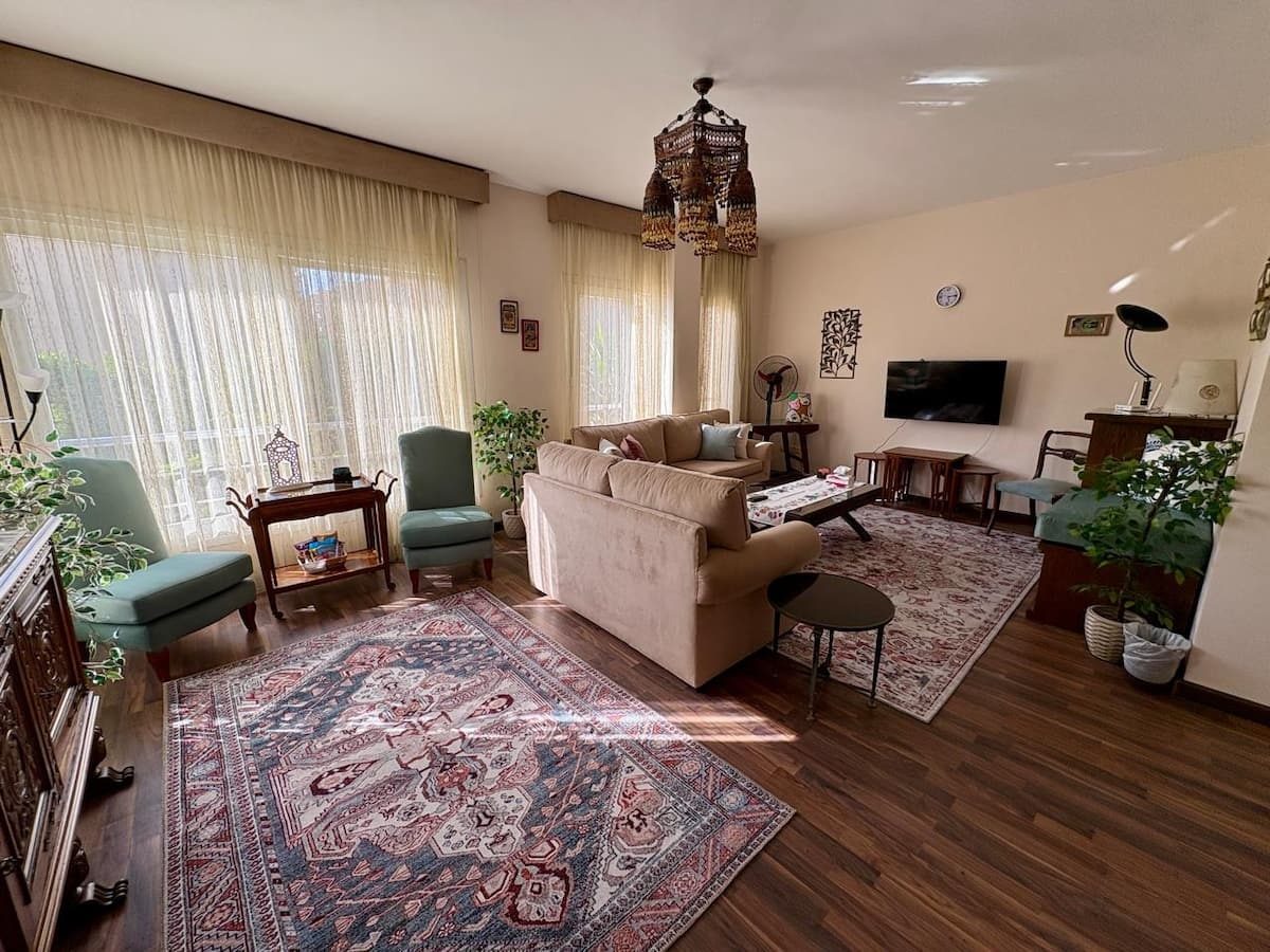 A second view of the living room, showing its layout and TV area