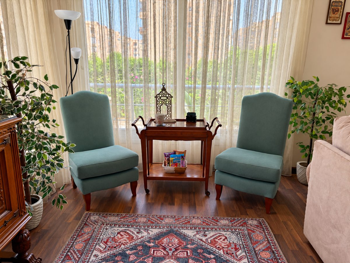 Two comfortable chairs beside the living-room windows