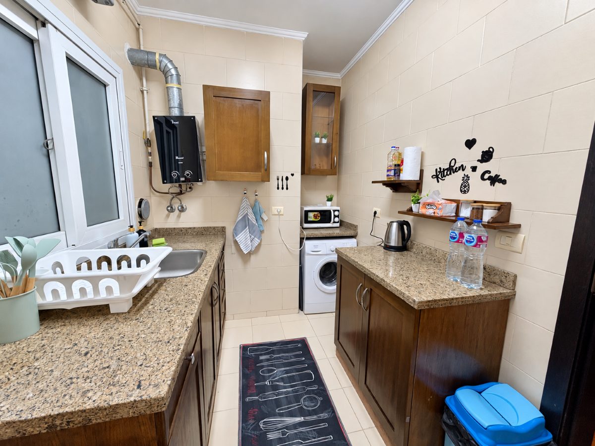 Kitchen with preparation space, sink, kettle, microwave and washing machine