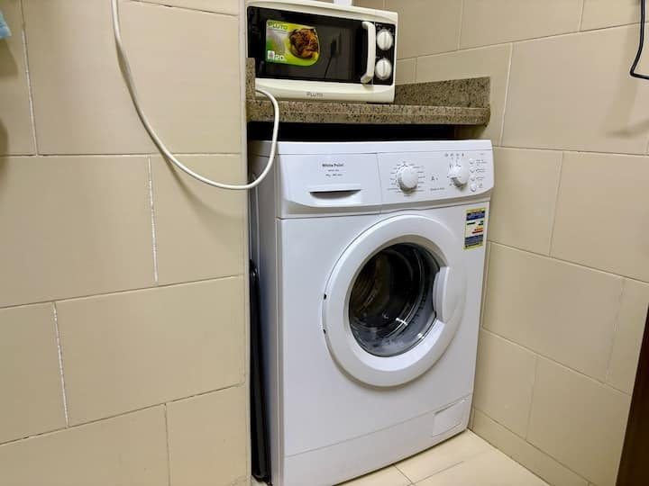 In-apartment washing machine, with the microwave above the counter.