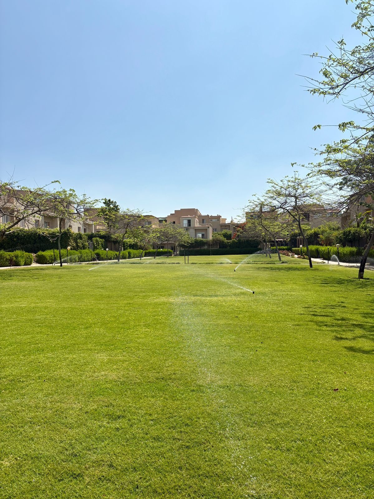 An open lawn within the shared residential grounds of Karma Residence.