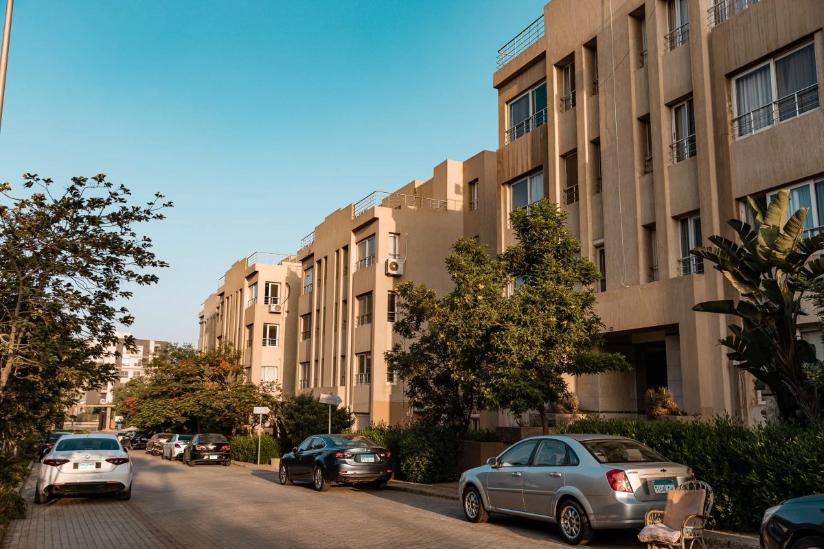 Street view inside the compound, with landscaped surroundings and parking along the road