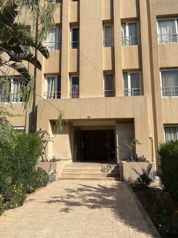 The apartment building entrance, showing the approach and entrance steps.