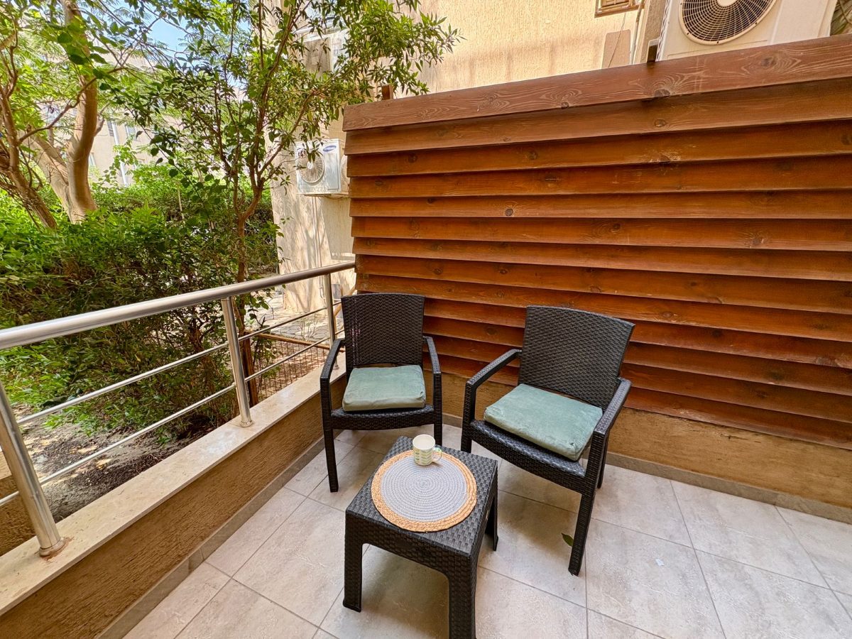 Private balcony with two chairs and a small table among the greenery