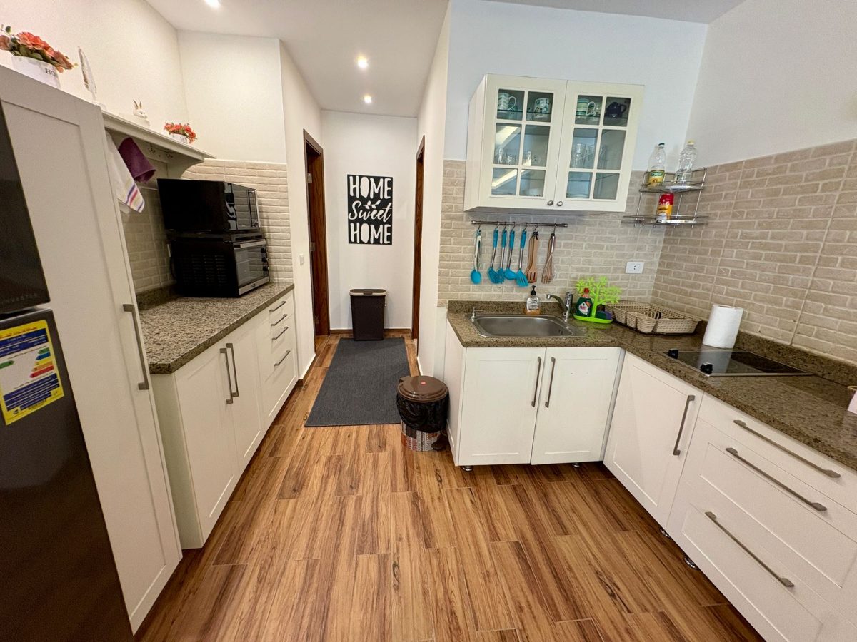 Kitchen with a hob, countertop oven, microwave and fridge