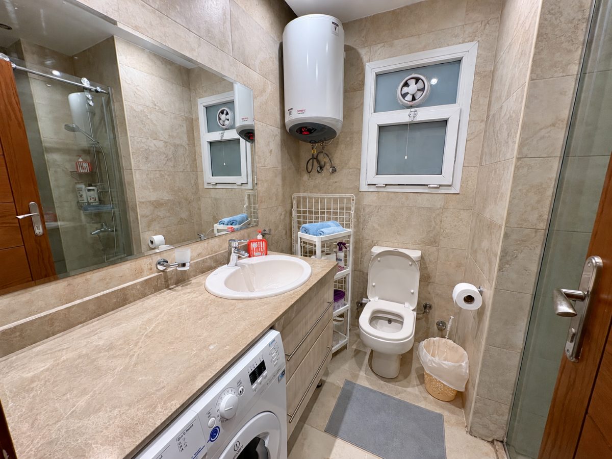 Bathroom with a shower enclosure, basin and washing machine