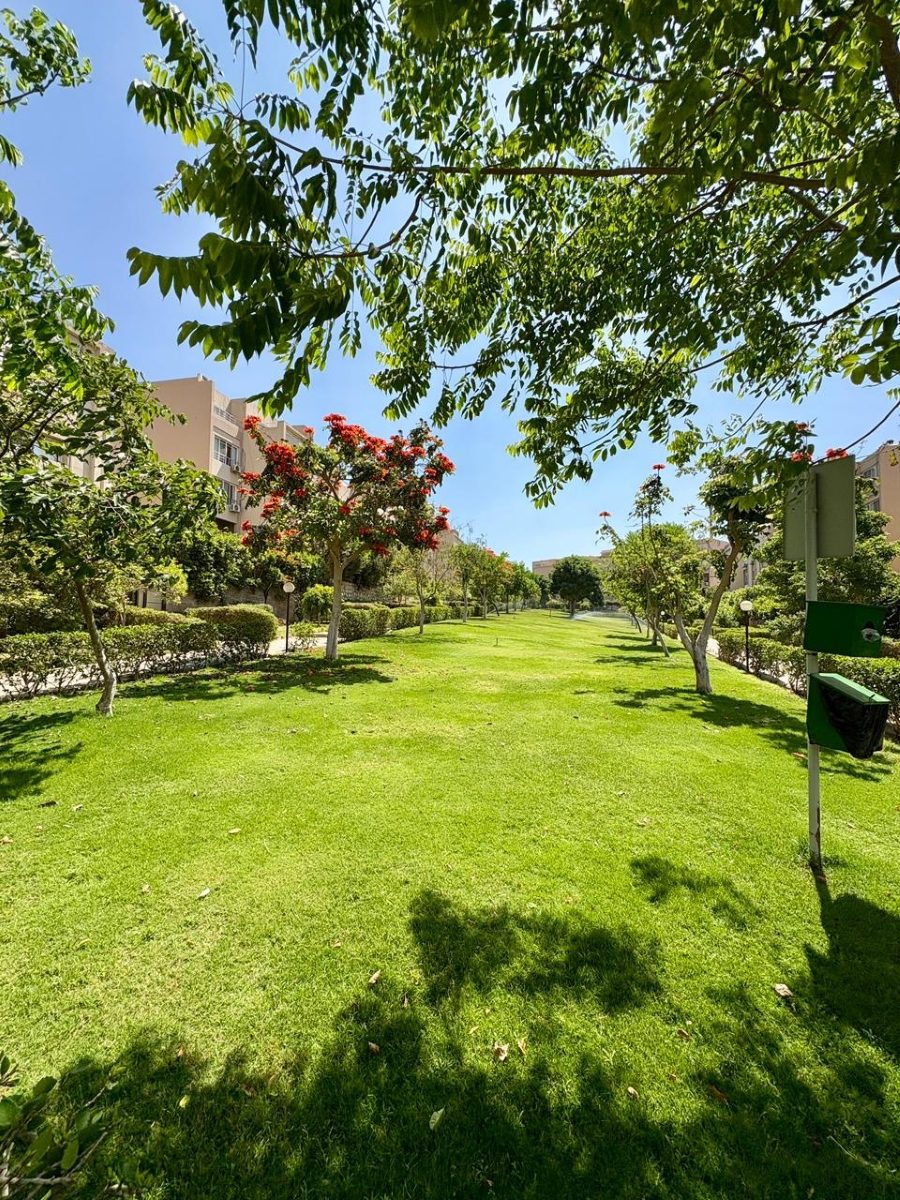 Sunny lawns, flowering trees and shared gardens within Karma Residence.