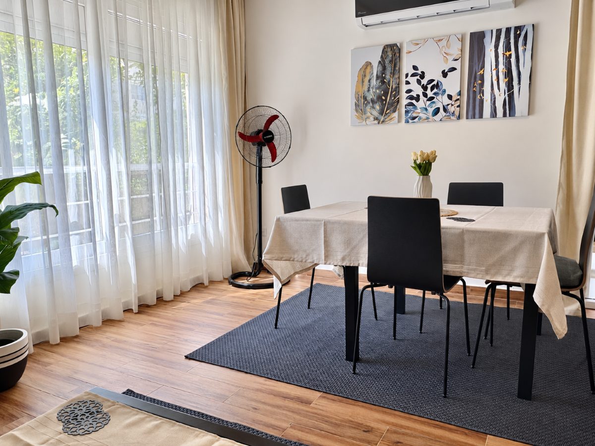 Dining table beside the window, laid out as a workspace