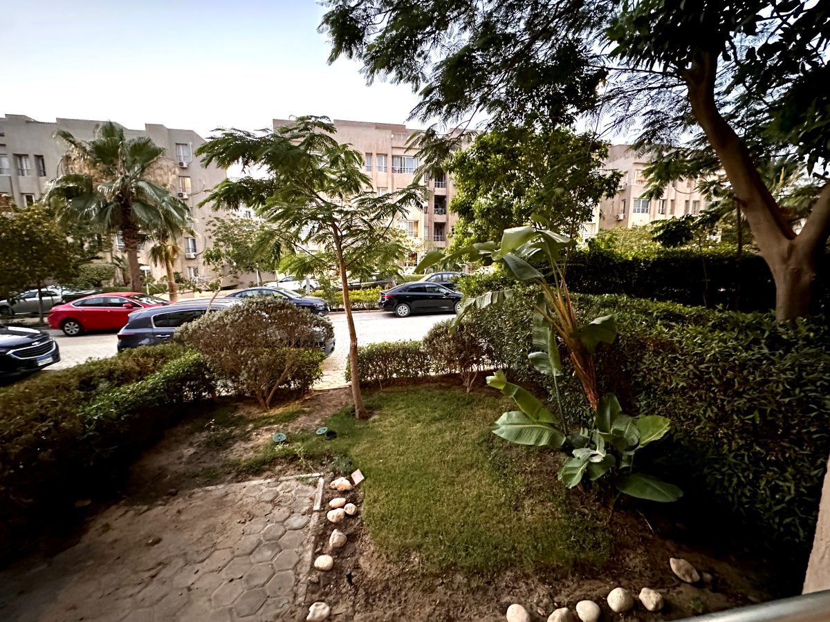 Planted grounds and a road beside the building inside the compound