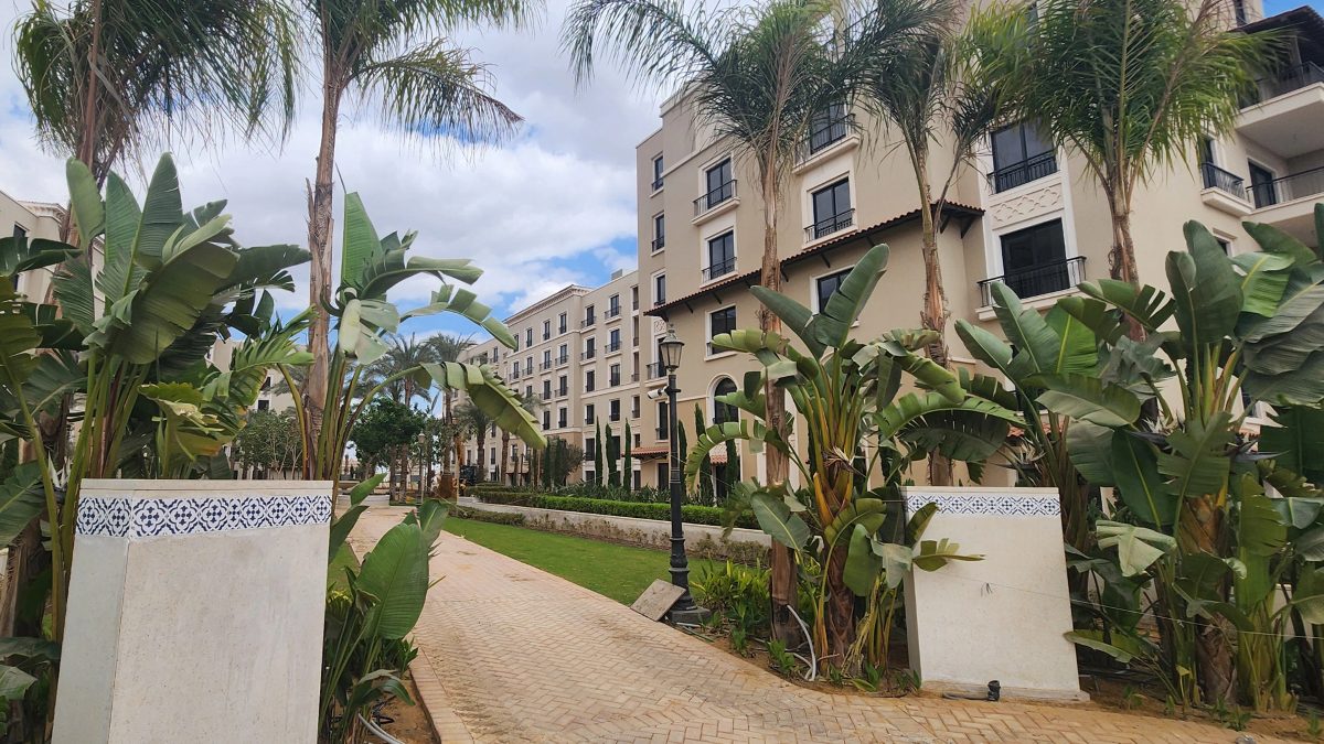 Landscaped paths and residential buildings within the compound. Guests have access to the shared grounds and playground.