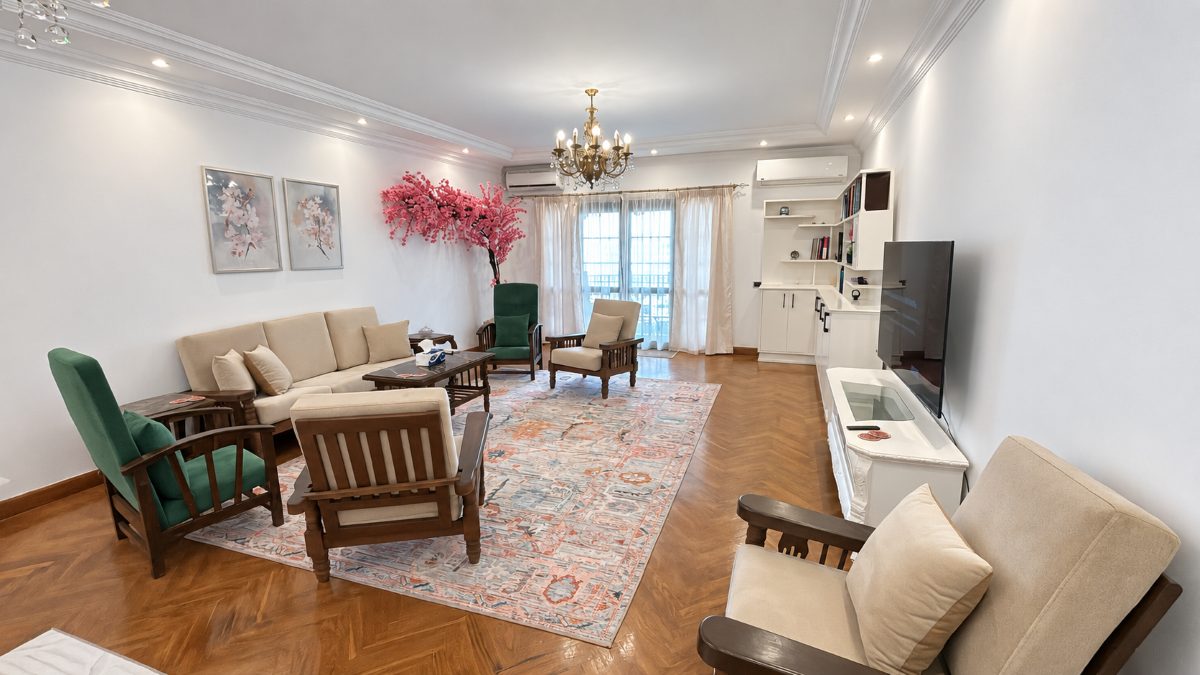 Living room with vintage armchairs, patterned rugs and a Smart TV