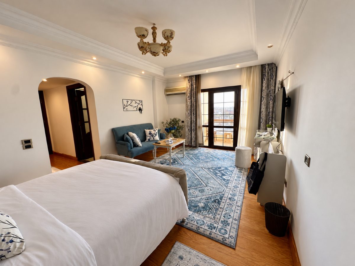 Main bedroom seen from the other side, showing the sitting area and balcony door